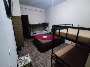 瓜鲁柳斯Hostel Aeroporto的一间房间,设有三张双层床