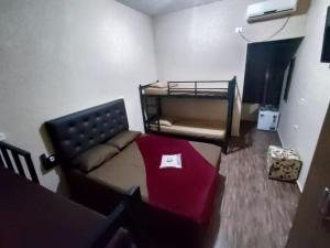 瓜鲁柳斯Hostel Aeroporto的一间小房间,配有沙发和一张双层床