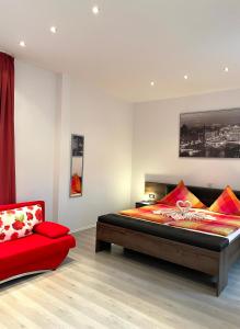 皮尔马森斯马特兹酒店的一间卧室配有一张床和一张红色椅子