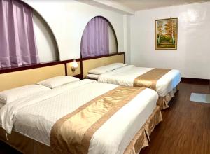 彰化市彰化樱山饭店的配有紫色窗户的酒店客房内的两张床