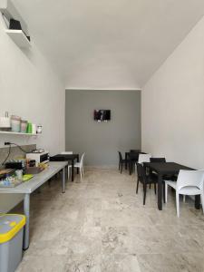都灵Hostel Turin Metro Young的用餐室配有黑桌和白色椅子