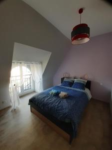 Saint-Julien-de-Piganiolgite de La Carrière的一间卧室配有一张带蓝色棉被的床和窗户。