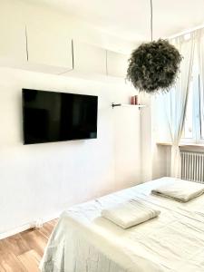 塞格拉泰white home near Linate的白色卧室设有壁挂式平面电视