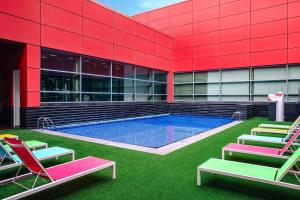 新加坡新加坡史各士皇族酒店的一座带草坪椅的游泳池的建筑