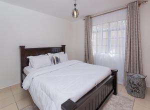 阿西里弗Athi Luxury Suites的一间卧室设有一张大床和一个窗户。