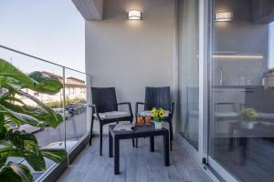 锡耶纳Siena Living Apartment的阳台配有2把椅子和桌子