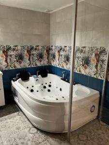 Kaunata信天翁旅馆的带淋浴的浴室配有白色浴缸。