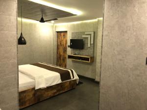 巴加Aariv Inn的一间卧室配有一张床,墙上配有电视