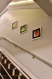 拉合尔Imperial Suites的楼梯壁上三幅画