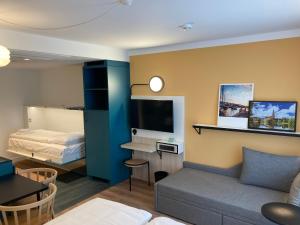 汉堡Aparthotel Adagio access Hamburg的客厅配有沙发和1张床