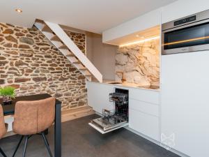 OrlitainTiny Fox Kluisbos的一间厨房和带石墙的用餐室