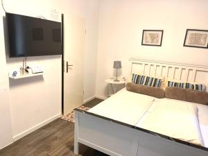 慕尼黑慕尼黑公寓式酒店的一间卧室配有一张大床和一台平面电视