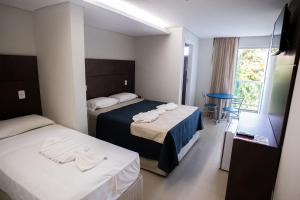 马拉戈日珊瑚之岸旅馆的酒店客房设有两张床和一张桌子。