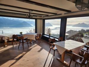 瑞吉卡尔巴德Hotel Bergsonne Rigi的餐厅设有桌椅和大窗户。