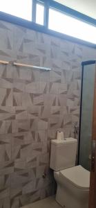 伊利亚贝拉Suite Ilhabela - com varanda e vista panorâmica的一间带卫生间和瓷砖墙的浴室