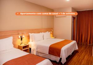 蓬塔格罗萨Luds Comfort Hotel的酒店客房设有两张床和一个标志,上面写着Armaarma客房的伽玛卡