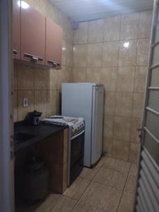 瓜拉廷格塔Kitnet completa的一间带冰箱和水槽的小厨房