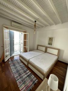 Megali AmmosMyconian Avra Apartment的一间卧室设有一张床和一个大窗户