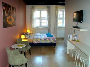波兹南U Romana的小房间设有一张床、一张桌子和椅子