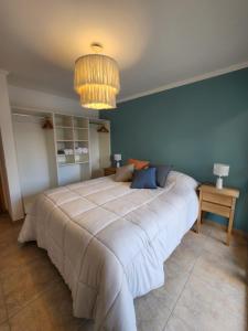 埃博森Andes Departamentos的卧室内的一张大床,卧室内有蓝色的墙壁