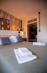 布拉干萨Inn Door 21 - Hostel & Suite的一间卧室配有一张大床和两条毛巾