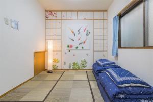 东京Shinjuku12min Shibuya15min Max10ppi Free-Wifi的一间卧室设有蓝色的床和窗户。