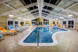 格尔夫波特格尔夫波特机场假日酒店的酒店大堂的游泳池,配有桌椅