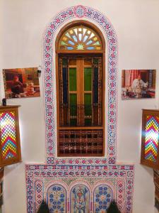 Fès al BaliPalais Fes Yahya的墙上有彩色瓷砖的窗口