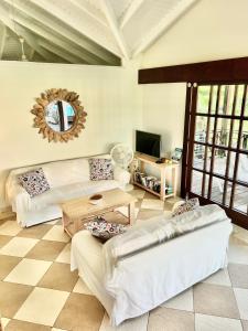 Blue BayVrijstaande BB BEACH Villa Azure的客厅配有2张白色沙发和1张桌子