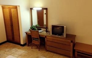 勿里达德高布利塔酒店的一间配备有书桌的客房,配备有一台电视。