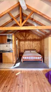 拉斯特朗卡斯Cabañas Bosque las Trancas的铺有木地板的客房内设有一间卧室和一张床。