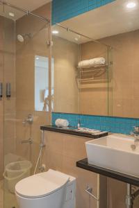 蒂鲁帕蒂REPUBLIC INN的一间带卫生间、水槽和镜子的浴室
