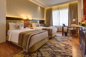 索拉普Balaji Sarovar Premiere的酒店客房配有两张床和一张书桌