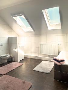 SüdbrookmerlandKastanienhof的浴室设有2扇窗户、卫生间和地毯。