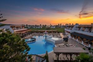 蒂加基盖亚村酒店的享有度假村游泳池的空中景致,享有日落美景