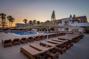 蒂加基盖亚村酒店的一个带躺椅的游泳池以及度假村
