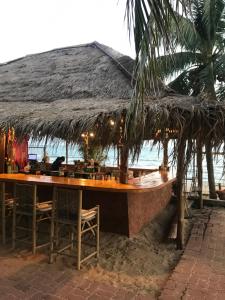 Ban Phlong Sawaidoublep的海滩上的餐厅,配有桌椅