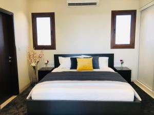 塞拉莱1-Bedroom in Forest Island & Oceanside View的一间卧室设有一张大床和两个窗户