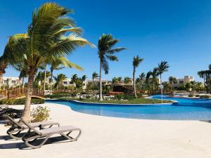 塞拉莱1-Bedroom in Forest Island & Oceanside View的度假村内拥有棕榈树和躺椅的游泳池