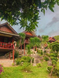 Baan Khai塔诺伊花园度假屋的一座棕榈树环绕的度假建筑