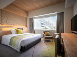 山形市山形大都会酒店的一间卧室配有一张床、一张书桌和一个窗户。