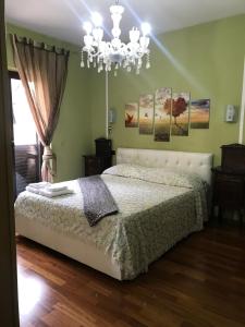 Pratola PelignaCasa Di Marzio的卧室配有白色的床和吊灯。
