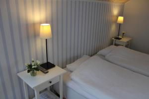 瑙沃斯塔尔贝肯纳古酒店的一间卧室配有一张床和一张带台灯的桌子