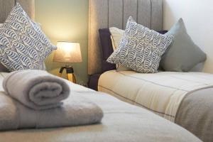 斯卡伯勒BAY VIEW Amazing SEA VIEWS!!! Yorkshire Coast Holiday Lets的酒店的客房 - 带两张床、枕头和毛巾
