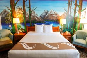 塞奎姆Quality Inn & Suites Sequim at Olympic National Park的一间带一张床的卧室,并装饰有一幅山脉画