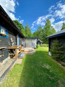 OckelboStugaNäraKungsberget - mysig stuga med kamin, grillkåta och vedbastu的房屋旁的后院设有木甲板