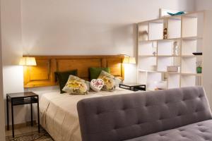 科拉托Amore Se Luxury Apartment的一间卧室配有一张带两张桌子和一张沙发的床。