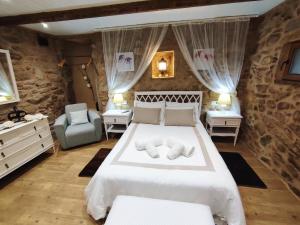 MazaricosA Cuadriña的卧室配有一张白色大床和一把椅子