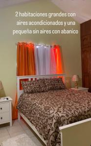 拉罗马纳Villa Victoria的一间卧室配有一张带橙色窗帘的床