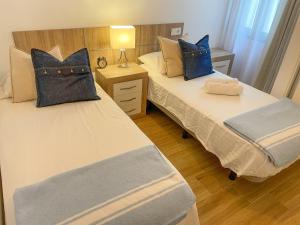 福恩吉罗拉La Rosa Apartment Los Boliches Fuengirola Malaga Spain的两张带蓝色枕头的床